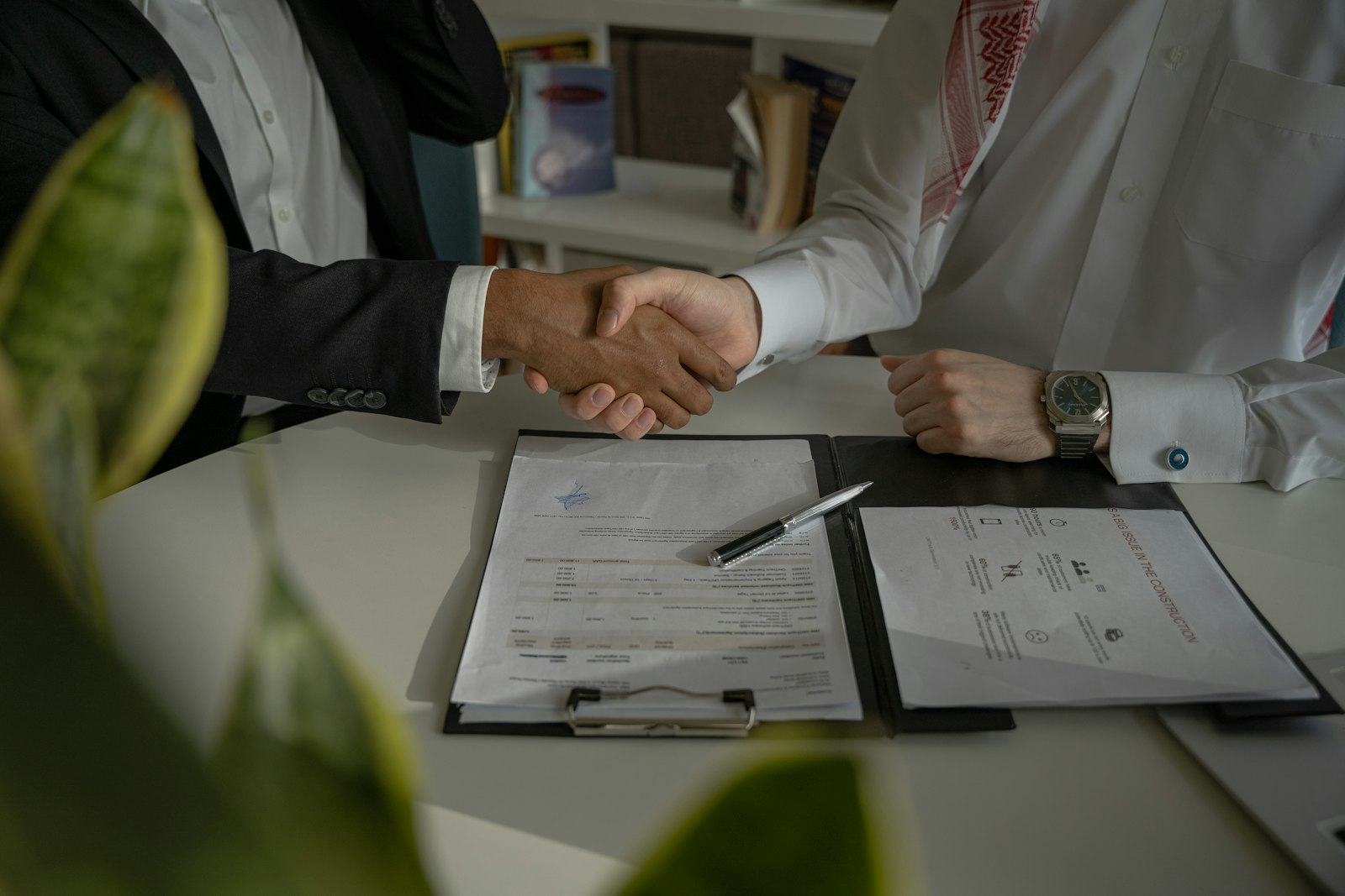 Dues persones es donen la mà sobre un contracte de treball
